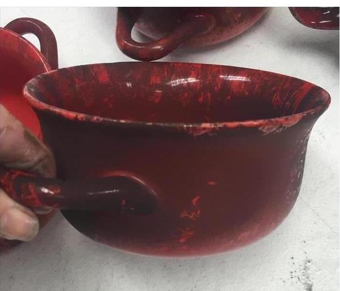 red bowls covered in black soot from a fire