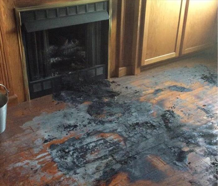 Fireplace log falls, burns hardwood flooring