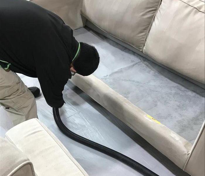 man cleaning white couch