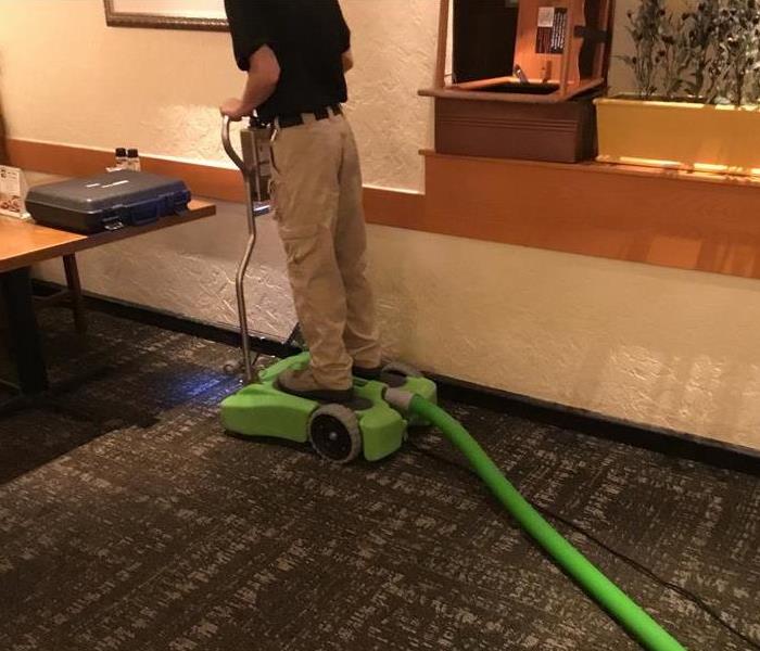 restaurant, wet carpet, man on green equipment