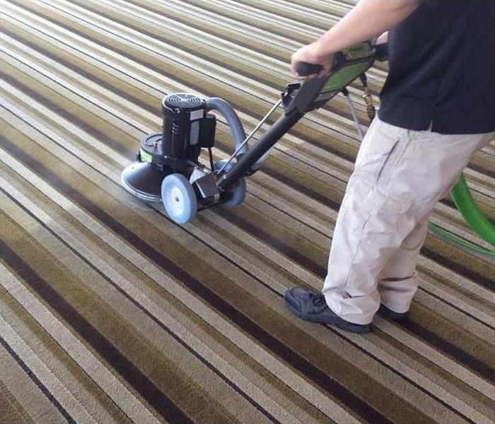 man with machine cleaning carpet