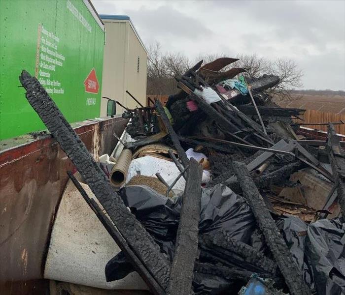 green truck, dumpster full of debris