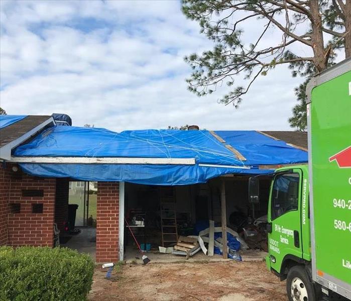 house roof with blue tarps